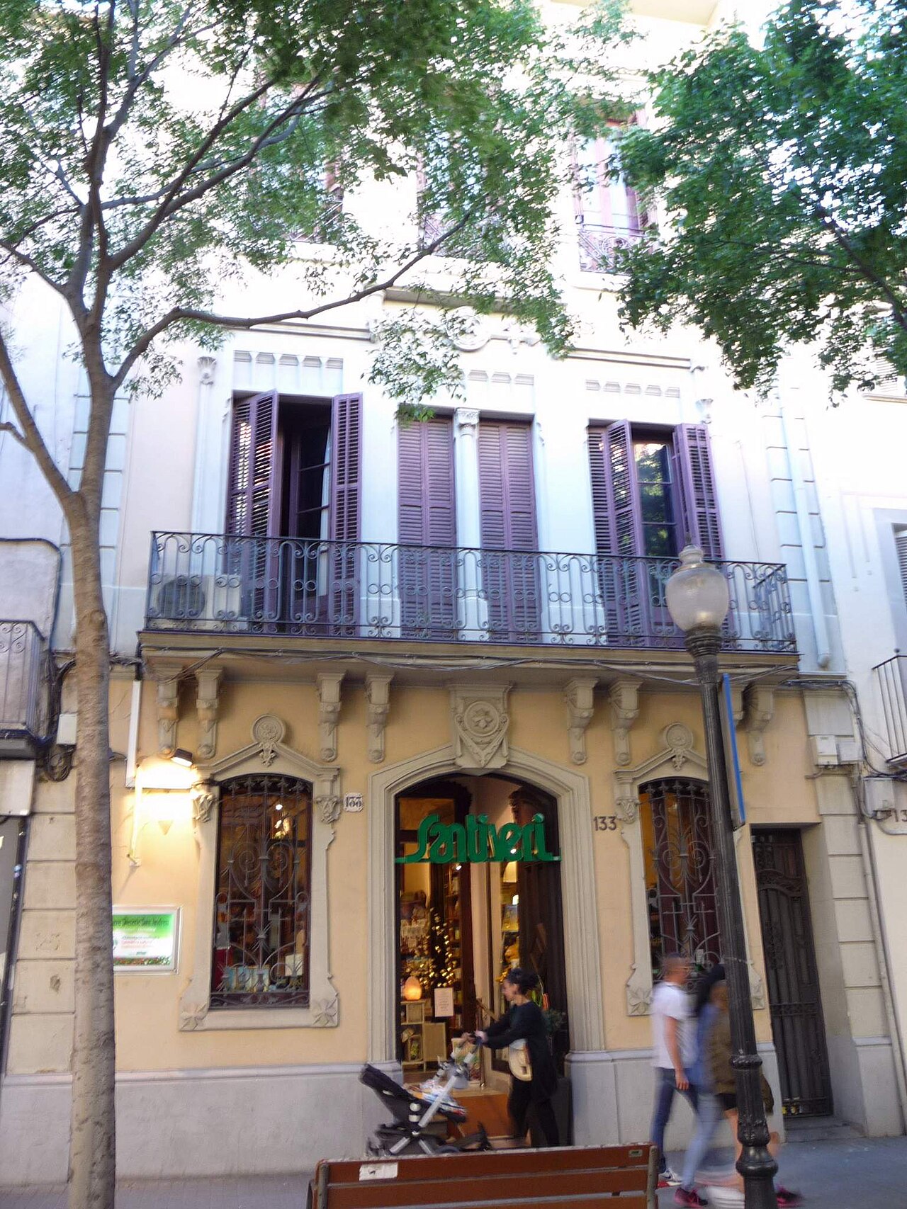 Façana amb balcons, comerç de barri i vianants a Sant Andreu, Barcelona